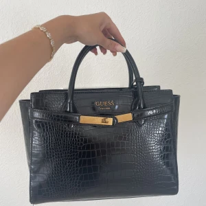 Guess väska - Guessväska köpt på zalando, knappt använd. Ett långt axelband medföljer.  Nypris 1500:-