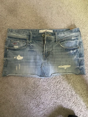 Lågmidjad jeanskjol - Super snygg Lågmidjad jeanskjol från Hollister, tyvär för liten för mig!  Midja tvärs över 41 cm! Längd på kjolen 28  cm Köp direkt för 300kr!