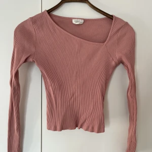 Topp från Gina - Perfekt passform. Sne urringning. Ljus rosa färg. Trendigt med figursydda toppar! Väldigt fint skick, inte nopprig!