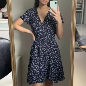 Blommig klänning - Säljer denna fina blommiga ”wrap” klänningen i storlek 34. Använd 2/3 gånger<3