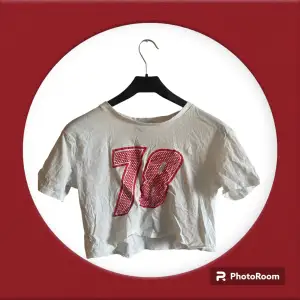 En vanlig vit crop top t-shirt med numer i rosa/röd tunt material och skön att ha på sommaren. Skriv gärna om det är något du undrar <3 