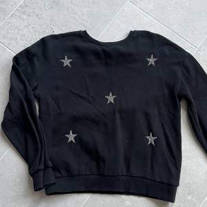 Svart mjuk tröja med 5 silvriga stjärnor på. Använd 2-3 gånger. Mycket bra skick. 