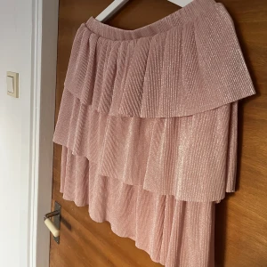 Glittrig kjol - Använd 1 gång, finns en liten liten svart fläck på baksidan (ca 0,5 cm) som inte syns pga av volangerna, bild på detta kan skickas vid förfrågan🥰