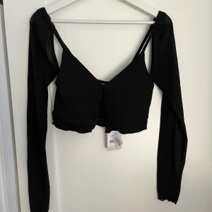 Svart topp - Svart topp med utskurna detaljer från NA-KD, storlek S. Aldrig använd! 