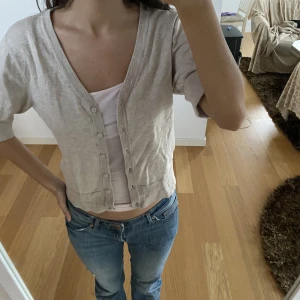 Kofta/tröja med trekvartsärm - Jättesöt tröja/kofta med trekvartärm som är beige! Jättesnygg och skön. Man kan både ha den öppen men också stängd. I mycket bra skick.