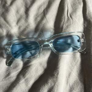 Blåa solglasögon med blått glas.