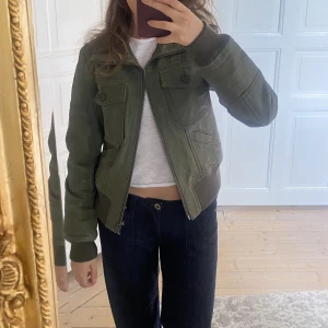 Grön skinnjacka - Så cool grön/khakifärgad/olivfärgad skinnjacka i ”matt” skinn. Perfekt skick. Storleken på lappen är L, men skulle snarare säga att den passar XS-M beroende på önskad passform💞 Bara att skriva vid funderingar! Kolla även in mina andra annonser❣️