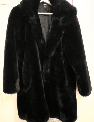 Snygg fuskpäls svart från Lindex stl M - Jättefin svart fuskpäls från Lindex stl M. Stängs med knappar fram använd fåtal ggr, fluffig och väldigt varm till vintern . Nypris 1195:-  Lycka till ☘️