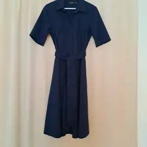 Ralph Lauren klänning i strl 6 (38)  Använd och tvättad endast en gång. Inga skavanker, som ny. Mörkblå färg. Går nedanför knäna precis på mig som är 165 cm.   Orginalpris: 2595 kr. 