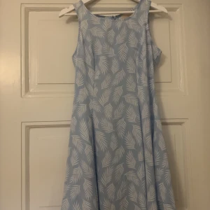 Klänning - En ljusblå jazzkläning med vitt mönster i storken 12/M från Chica London. Nyskick 