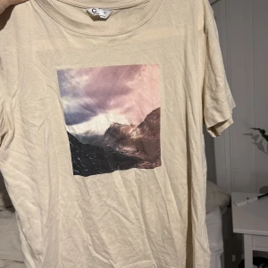 T-shirt med tryck  - Säljer denna beiga t-shirten med tryck på. Säljer pågrund av att den inte används, den är i storlek M men passar även en S.