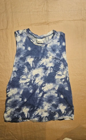 batik topp - Fin topp/linne i bomull från Gina Tricot med blåvitt batikmönster och vida hål i ärmarna. Storlek small.  Går ganska högt upp i halsen men inte turtleneck. Fint skick