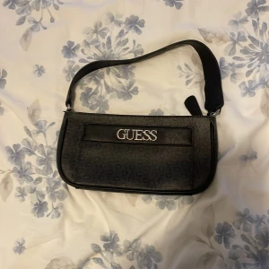Guess väska  - Säljer min Guess väska som inte används mer, köptes i Guess butiken i Göteborg för 900 kronor. Den har rostat lite där det står Guess men inget man kollar på när man använder väskan. Super fin väska annars🤍 går ner till 100 vid snabb affär!!!!