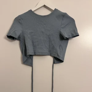 Topp  - Fin blå magtopp med snörning runt magen. 