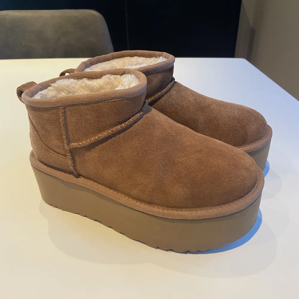 UGG Ulra Mini Platå i färgen Chestnut, strl 36. Skorna är nya (använda en gång) och säljes pga en liten missfärgning på vänster sko (se bild, röd ring). . Skor.