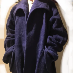 Vinterkappa - Stor, varm, mörkblå vinterkappa💙blåare än vad den ser ut på bilderna. Jag är 170cm och går lite drygt över knäna på mig. Gissar strl M/L, men sitter bra på S också. Lite blekt i krage/ärmar och innertyget är löst på ett par ställen. Använt men fint skick.