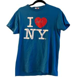 Blå I love NY t-shirt storlek S. Passar även XS. Rätt smal. Defekterna syns på trycket annars är den bra.  Fråga om du vill ha fler bilder eller annat. Snabba affärer prioriteras.