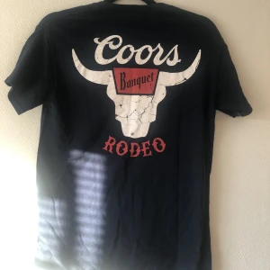 Urban Outfitters Coors T-shirt  - Coors graphic t-shirt från Urban Outfitters med cool rygg som passar både killar och tjejer! 