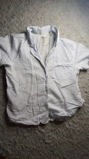 H&M pyjamasset - En supersöt blå-randig kortärmad pyjamas tröja från H&M med ett par shorts till. Använd ganska mycket, säljer pga att den är för liten!❤️