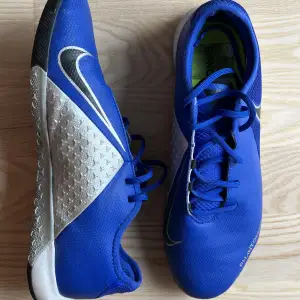 Size EUR 42. Indoor training shoes. Blue, Black, Metallic. Good condition and one scratch on the side (2nd picture). 