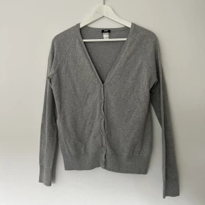 grå stickad kofta - grå stickad kofta från HM i bra skick. strlk M men passar mig som är xs/s men kanske aningens mot det baggy hållet än mot det tajtare. sitter tajtare runt höfterna så passar perfa till low-waisted jeans. 🤍