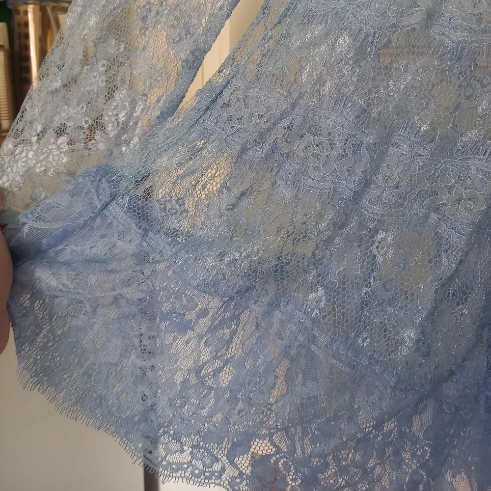 Beautiful blue lace blouse with high collar and a lovely button on the back. Blusar.