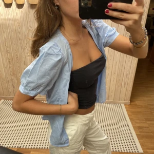 Blå blus med knäppning - Brukar ha både öppen som en skjorta och stängd som en blus! Bra skick och söt