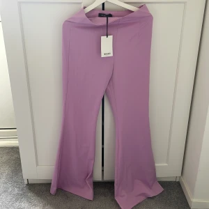 Ljuslila Byxor - Oanvända byxor från madlady. Ljuslila/lavenderfärgade. Stretchigt material, vida ben.