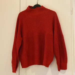 Röd stickad tröja - Mysig stickad tröja från Monki. Mellanhög krage. Sparsamt använd.