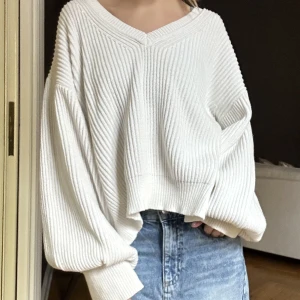 Stickad tröja - Säljer den här vita stickade tröjan, den har balongärmar och sitter så gulligt, jättefint skick och jag säljer även kjolen på bilden 