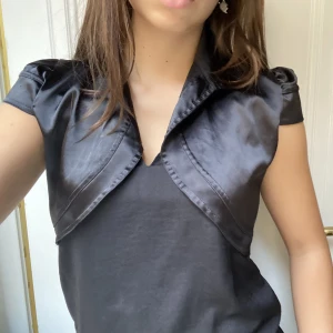 Svart bolero  - Snygg svart bolero i glansigt material! Passar S och M. Mycket bra skick🫶