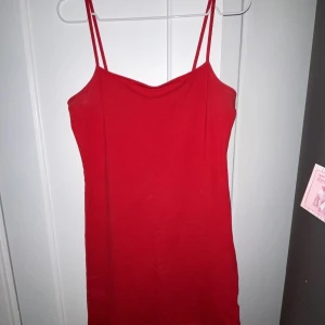 Tajtklänning Röd - Superfin tajt, kort klänning i en röd färg. Sitter superfint på kroppen och formar sig efter hur du ser ut. Tunna band upptill. Från H&Ms divided avdelning  