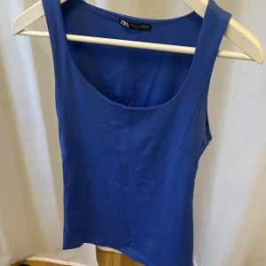 Blå topp från Zara - En blå topp/linne som är multifunktionell där man kan ha på sig den både framifrån och bakifrån i fint skick utan några fläckar eller hål