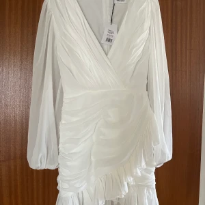 Vit klänning - Säljer denna fina vita klänningen som jag har köpt av en annan på Facebook marketplace. Jag säljer klänningen på grund av att den var för liten. ☺️😍   Kan också tänka mig byta denna mot en storlek 38/M.😊  Storlek: 36/S Märke: Showpo Nyskick med lapp på