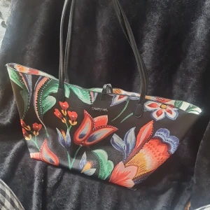 Handväska - Vändbar Desigual handväska med tillhörande mindre väska.(mindre väska ej vändbar är vit) Den mindre väskan går att ha i den större väskan ,men också som en egen väska. 