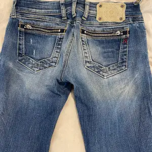 Äkta Replay jeans med fina detaljer. Fint skick. Är en av hällorna som lossnat men det löser man lätt med ett par stygn (se sista bilden).   Märke: Replay  Storlek: 28/34 Modell: Jennpez (raka ben och låg midja, figurnära)  Waist 28 motsvarar ca 75,5 cm.