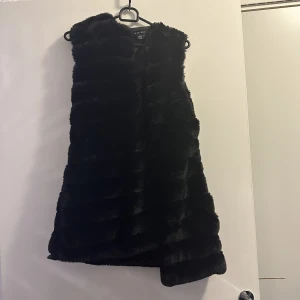 Svart pälsväst  - Päls väst i bra skick, använd några gånger. Storlek M men kan passa en S, hör av er för mer bilder