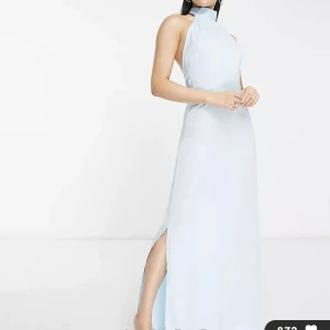 Balklänning ljusblå - Klänning från Asos av märket Unique21. Strl 34.  Är i helt nytt skick, oanvänd och prislappen sitter kvar. Sitter jättefint och hade varit en perfekt balklänning.  Säljer den för jag valde mellan denna och en annan. Klänningen skickas i påsen den kom i. 