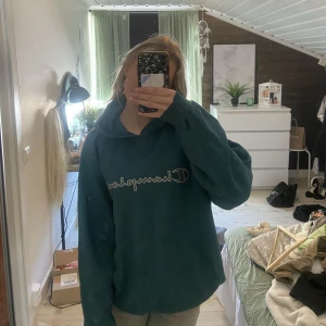 Oversized champion huvtröja - Snygg huvtröja från champion. Mörkgrön med tryck fram, har en liten fläck på ärmen.