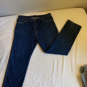 Mörkblåa vintage jeans - Ett riktigt skyggt par lågmidjade jeans som har en baggy passform. Köpta second hand men har inte kommit till användning