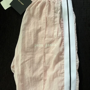 Palm Angels Track Pants Baby Pink -  Loose fit, endast testade, kommer med tags, 10/10 cond.  Byten kan vara intressant. 