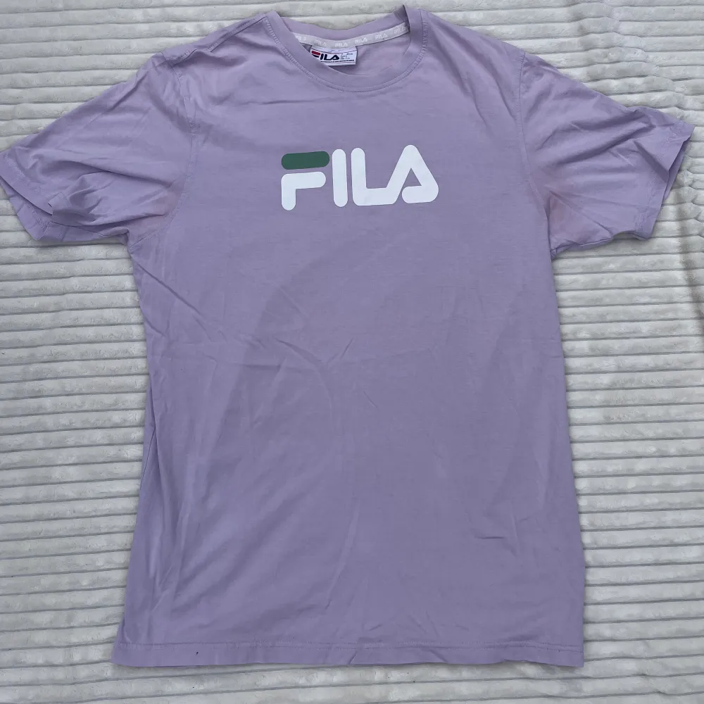 Ljuslila/lavendel t-shirt från Fila. Knappt använd⭐️(ser rosa ut på mig men den är ljuslila)  Storlek: L Min längd: 180 cm. T-shirts.