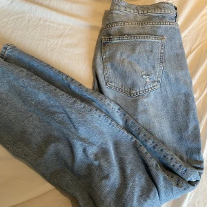 Jeans lågmidjad  - Jeans med raka ben och låg midja från Gina Tricot med lite slitningar. Storlek 44 150kr plus frakt