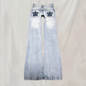 Jeans - Midja: ca 62 innerbenslängd: 80 Bootcutjeans med mörkblå kronor på bakfickorna. Sitter midwaist. OBS! små i storlek(använd mått). Oanvända, fint skick!!🤍
