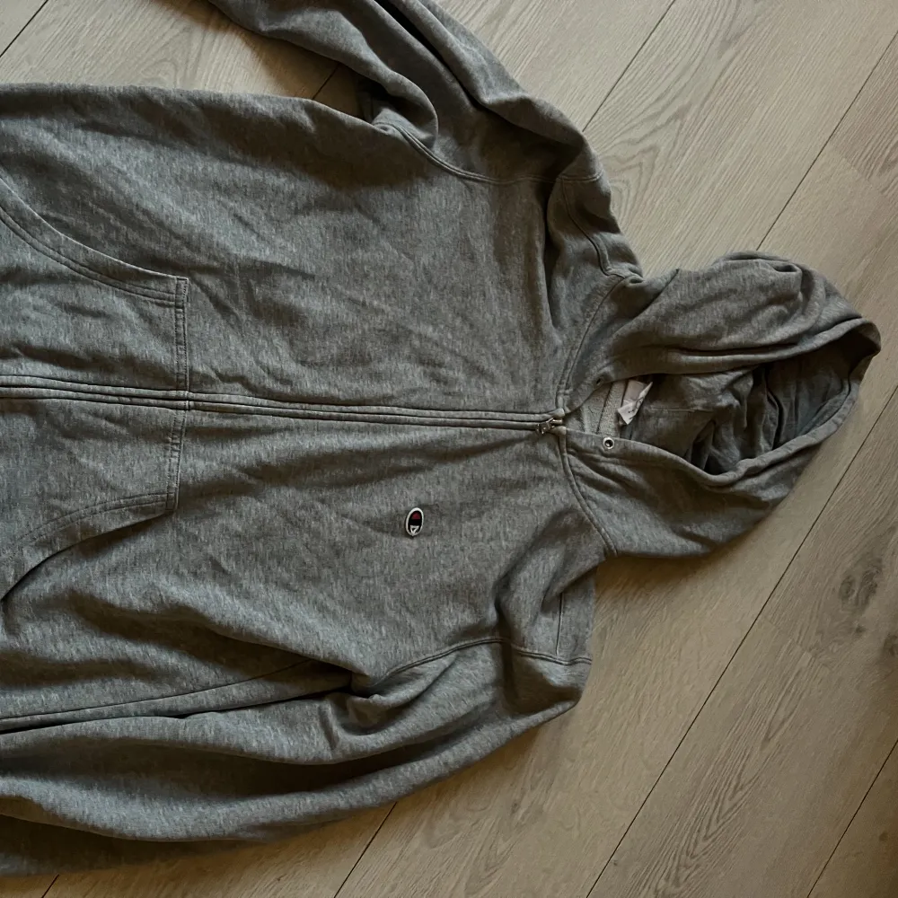 En grå championzip tröja som inte kommer till användning, snöret saknas i luvan men det går att sätta i ett nytt🫶🏼. Hoodies.