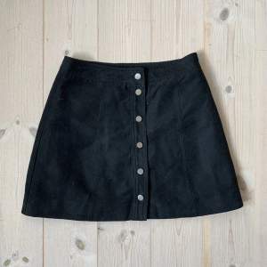 A-line kjol med metallknappar i faux-suede material. Insidan är glansigt foder. Passar såklart bättre på någon med mindre höfter än mig, jag är 175 och har igentligen strl 38/40