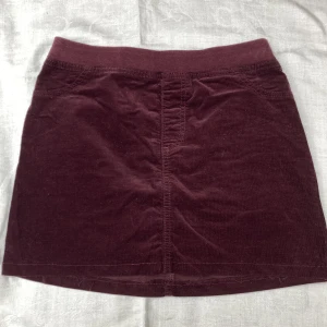 Lila mini kjol - Mörklila mini kjol i Manchester tyg! Har sytt om den, så uppskattar den till en strl XS!