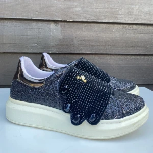 Alexander McQueen sneakers - -Svarta, glittriga Alexander McQueen sneakers  -Storlek 39  - Använda med bruksslitage, men trots detta i mycket bra skick  - missfärgning, se bild
