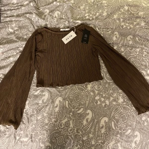 Tröja med vida ärmar  - En brun ribbad topp från NAKD som endast är provad. Nyskick och mycket fin.  Säljer då den inte kommit till användning. 🤎🤎