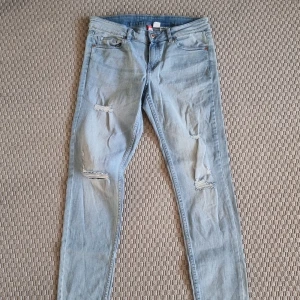 Jeans  - Ljusa lite stretchiga jeans med slitningar. Slim fit. Låg midja. 